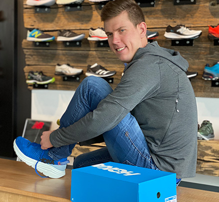 Man trying on shoes at a store in West 5